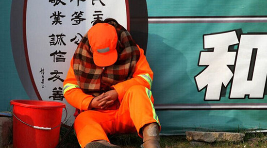 每天必須12小時(shí)在路面值守以時(shí)刻保持路面的清潔，環(huán)衛(wèi)工人只能蜷縮在馬路啃饅頭、打瞌睡